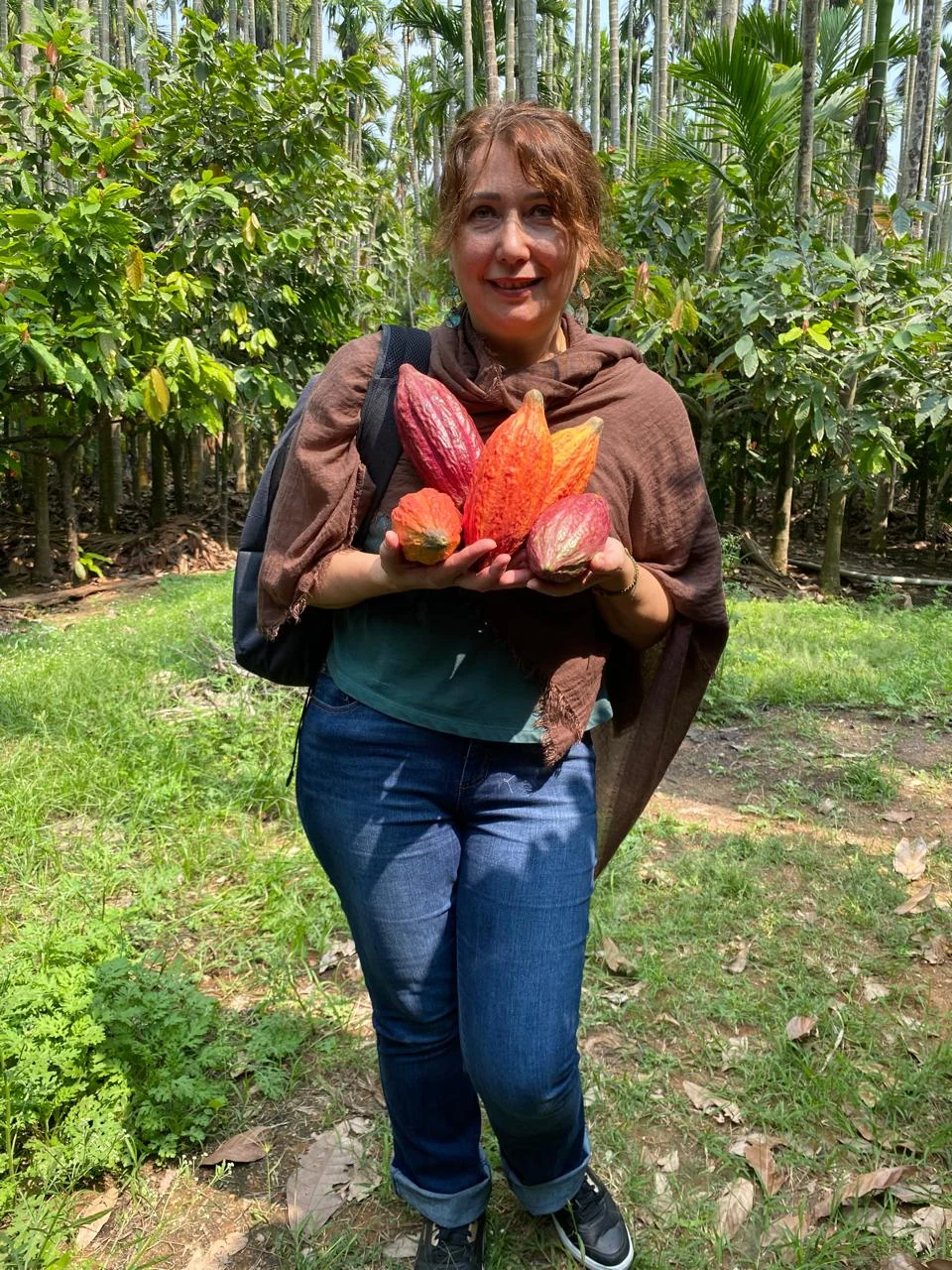 Liliya holding cacao pods at a cacao farm